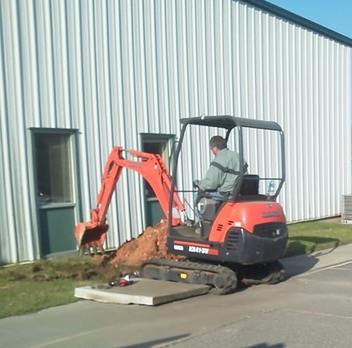 Mini excavator doing plumbing-related excavation work