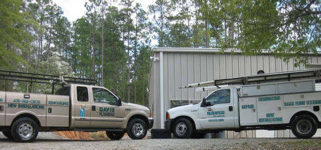 Two branded work trucks parked side by side